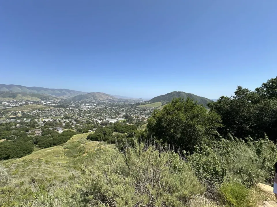 Town and hills seen past the oaks on a ridge trail
