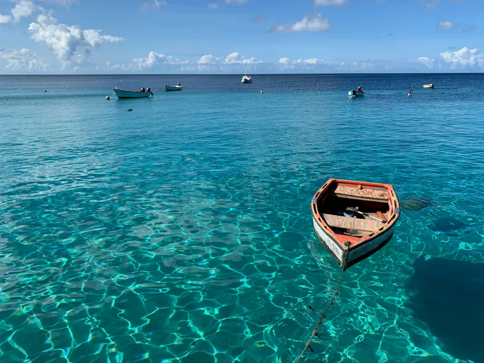 Small rowboat floating on clear turquoise Caribbean water