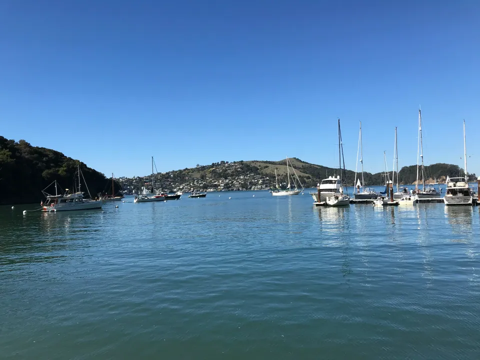 Sailboats anchored in blue bay below hillside town