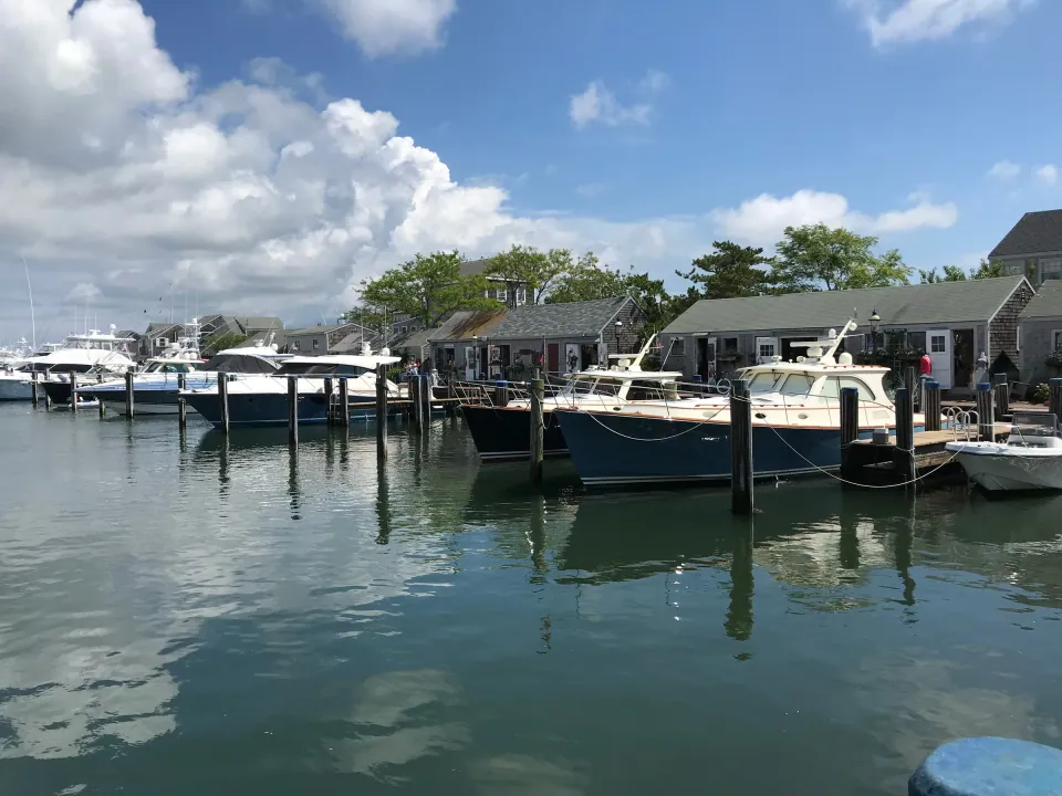 New England harbor docks with boats and shingled cottages