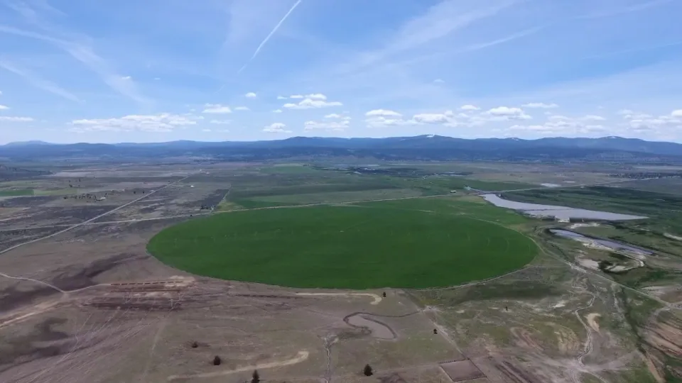 Aerial of green center-pivot circle on high-desert ranchland