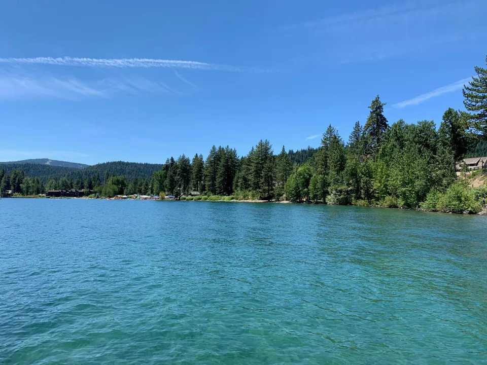 Turquoise mountain lake edged by dense conifer forest