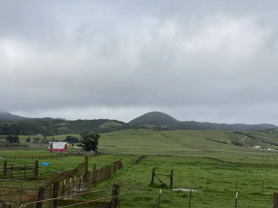 Red barn and corrals below a volcanic peak