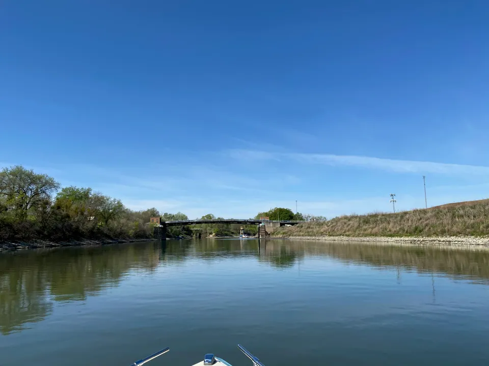 Calm Delta slough reflecting blue sky and green levee banks