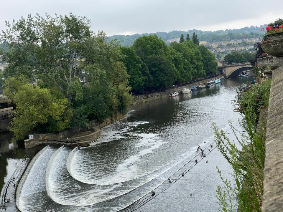 Bath Pulteney Weir cascading on River Avon, green banks