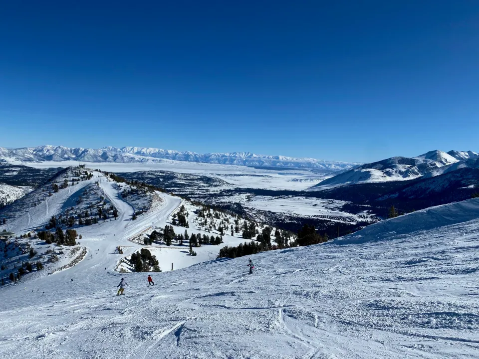 Mammoth ski slopes overlooking snowy valley and distant ranges