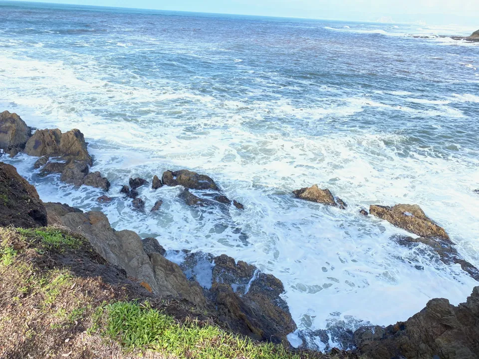 Winter surf exploding white over dark coastal rocks