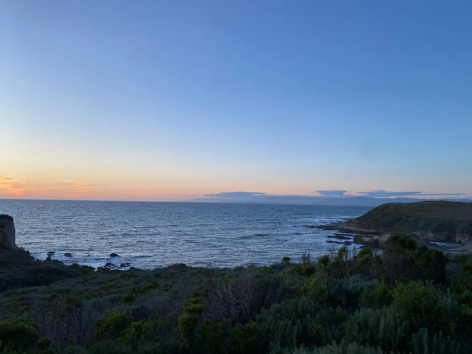 Dusk glow over rocky coastline and calm Pacific
