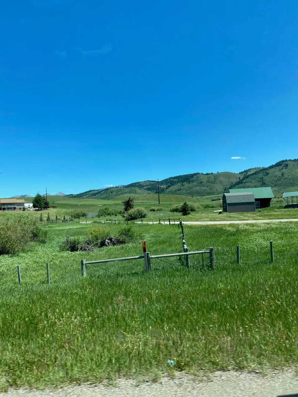 Ranch meadows and fences under green hills