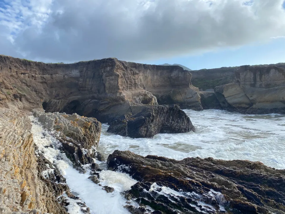 Surf pouring through sandstone cliffs