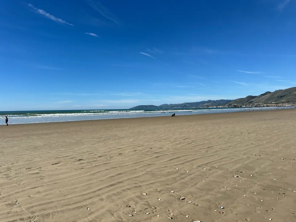 Wide beach at low tide with the hills beyond