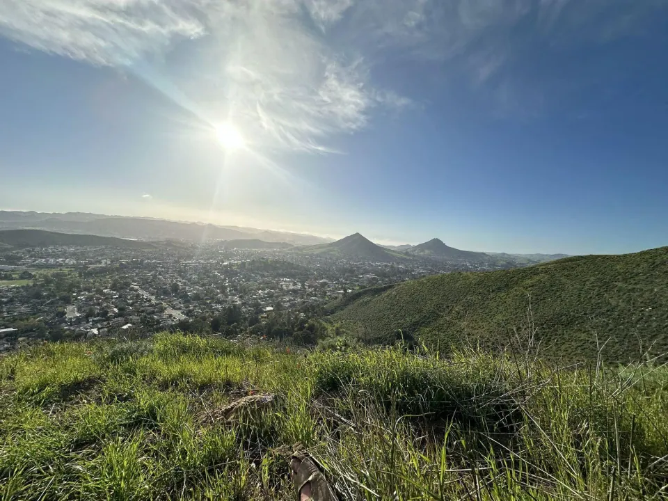 Green hills and the town below under a bright sky